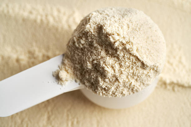 istock Whey protein powder in a measuring cup, close up 2206560513