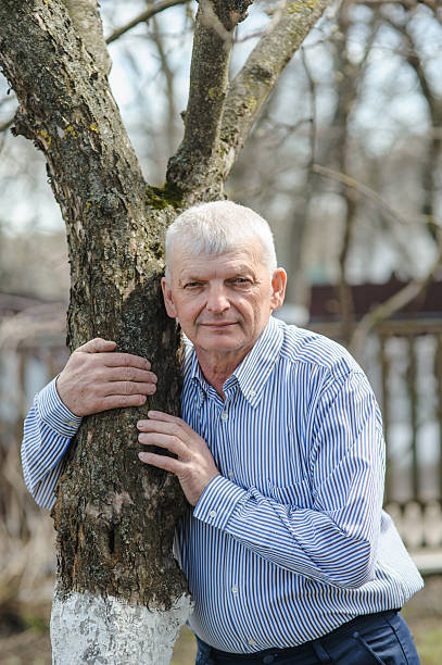 istock The pensioner is leaning on a tree and smiling beautifully 2206562876