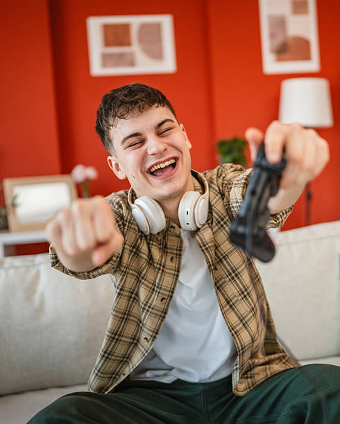istock man play console video games at home hold joystick controller have fun 2206563153