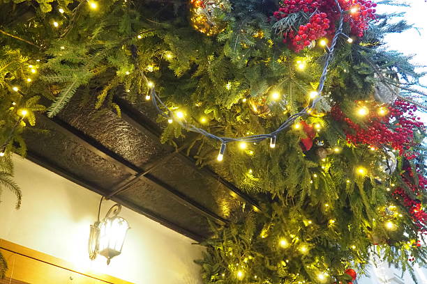 istock Lush greenery with sparkling lights and red berries creates a festive atmosphere at a quaint establishment, inviting passersby to enjoy the holiday cheer. New Year's street garlands 2206564079