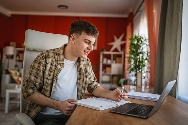 istock young man student learn and prepare exam from notebook and laptop 2206566544