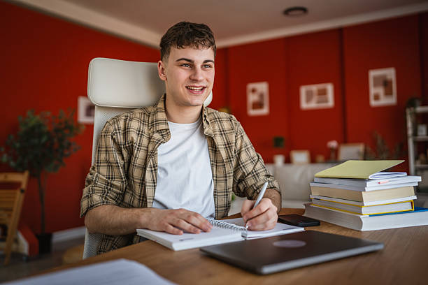 istock young man student learn and prepare exam from notebook and laptop 2206566551