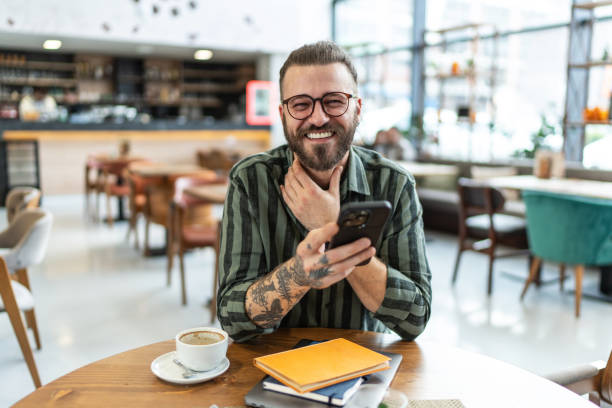 istock Businessman using smartphone and smiling in a cafe 2206568664