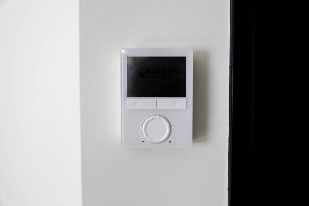 istock Digital thermostat mounted on a white wall with a screen 2206572845