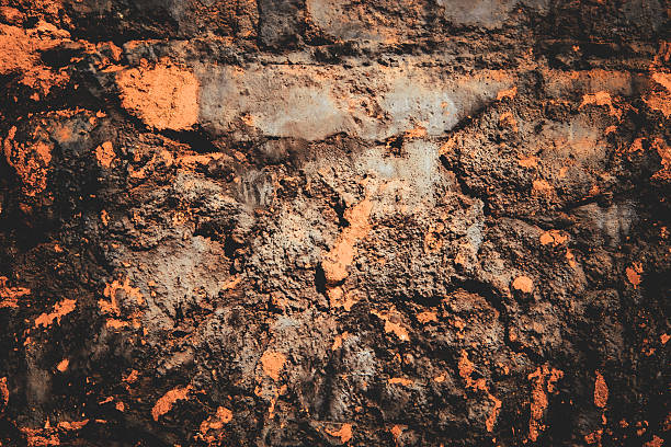 a weathered black relief grunge background with orange iron oxide appearance rough wall design element