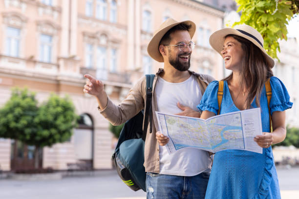 istock Happy couple exploring a city with a map under sunny skies 2206577089