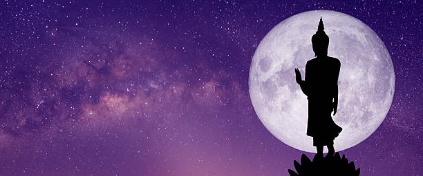 istock A silhouette of a Buddha statue stands peacefully under the full moon. 2206577374