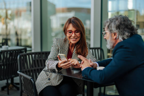istock Business partners using smartphone at outdoor cafe 2206578152