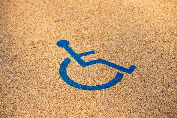Blue wheelchair symbol painted on a grainy surface, promoting accessibility and inclusivity for people