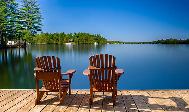 istock Long exposure captures a glassy lake, reflecting sky and trees. 2206582496