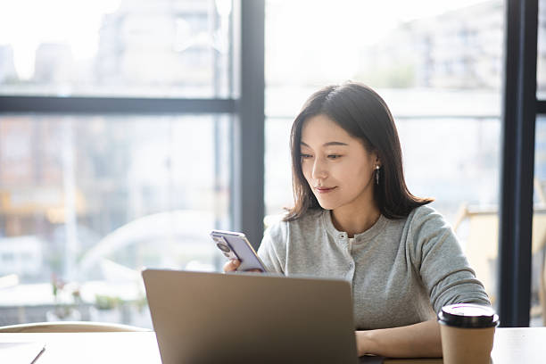 istock asian female using smart phone in coffee shop 2206583888
