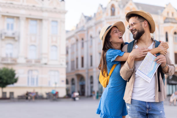 Amidst a historic town setting, a couple exudes happiness and affection. Their shared joy and scenic backdrop of architecture highlight romance and adventure in urban travel.