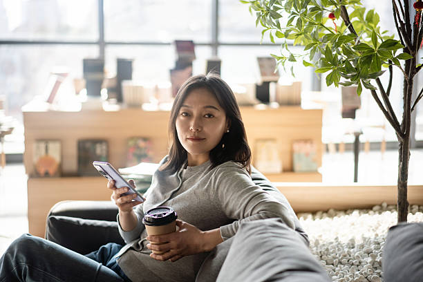 istock asian female using smart phone in coffee shop 2206587115