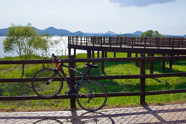Metal bicycle rack stands empty in a grassy field, awaiting cyclists
