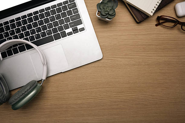 Creative workspace with laptop, headphones, notebook, and glasses..