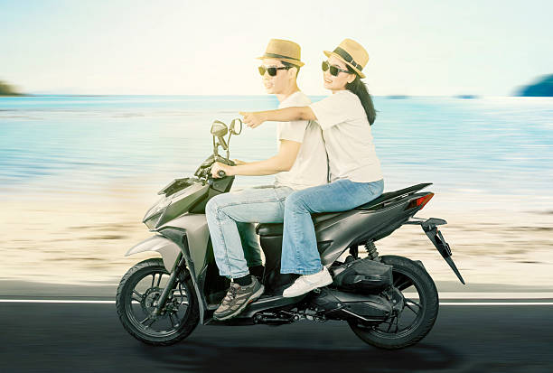 istock Happy Couple Riding a Scooter on a Scenic Beach Road 2206601993