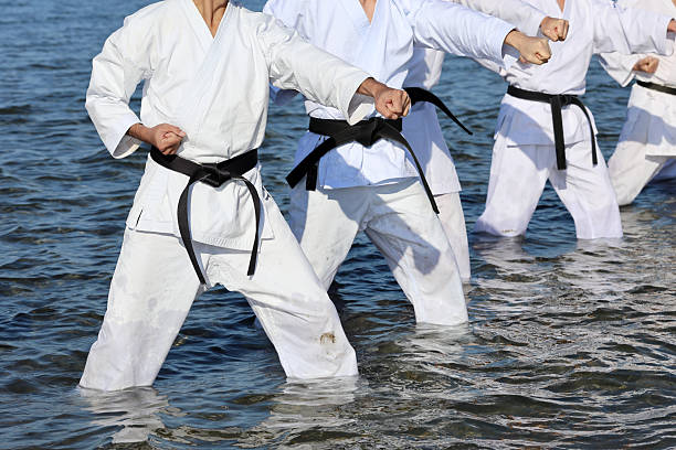 Kagawa, Japan - January 02, 2025 : Japanese karate men training of karate fighting in midwinter of a new year at Ichinomiya Beach, Japan