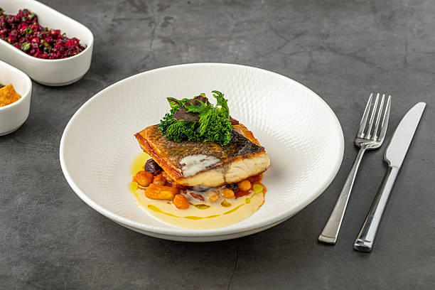 istock Crispy-skinned pan-seared fish fillet with chickpeas, creamy sauce, and fresh greens 2206609111