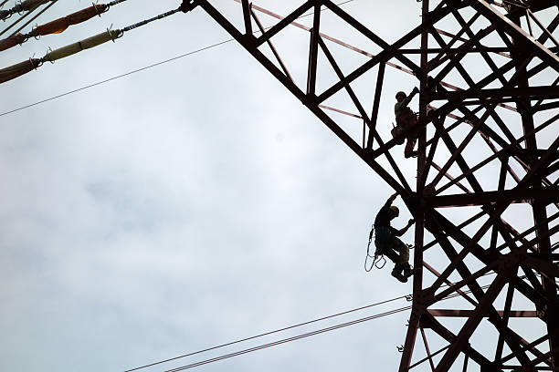 istock Building electricity pylon - two technician climbing electric pole 2206610694