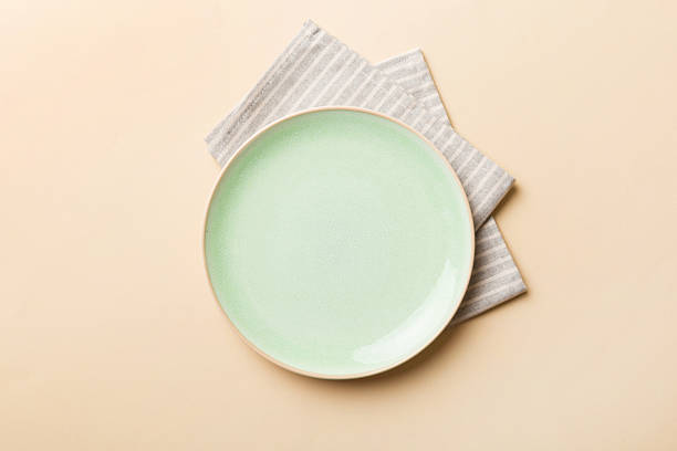 istock Top view on colored background empty round green plate on tablecloth for food. Empty dish on napkin with space for your design 2206612613