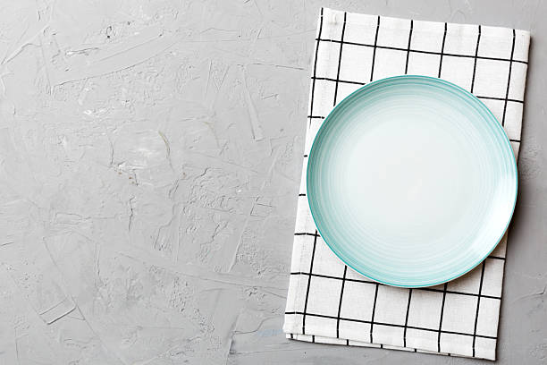 istock Top view on colored background empty round blue plate on tablecloth for food. Empty dish on napkin with space for your design 2206612643