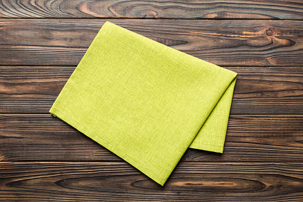 istock top view with green kitchen napkin isolated on table background. Folded cloth for mockup with copy space, Flat lay. Minimal style 2206612647