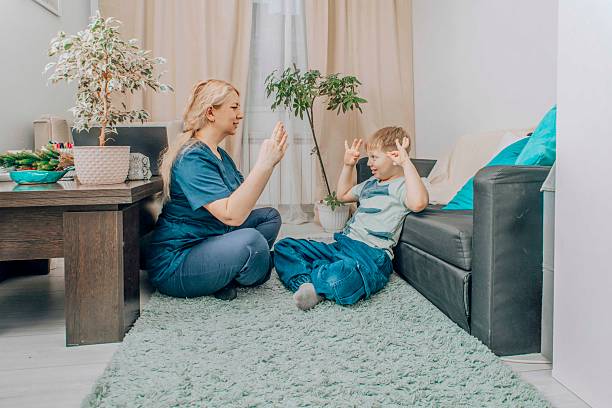 istock speech therapist engaging with young boy in nonverbal communication training, living room with warm decor, concept of education and cognitive skills development 2206618260