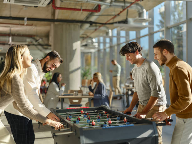 istock Happy colleagues playing table soccer during a break at casual office. 2206618463