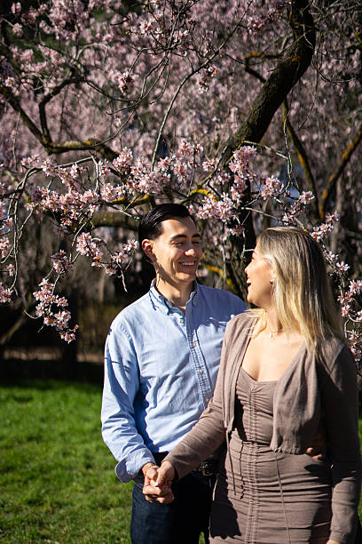 istock Latin couple holding hands under blooming trees in springtime 2206619439