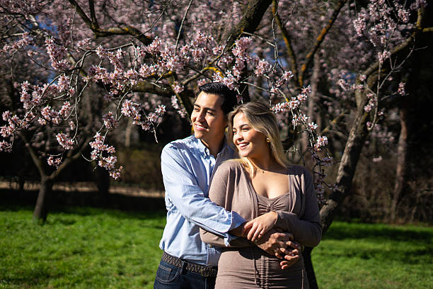 istock Latin couple embracing under blooming almond tree in springtime 2206619458