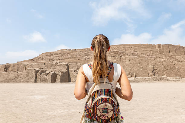 istock Young woman with backpack exploring ancient ruins under blue sky in Lima 2206621066