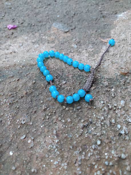 Blue beaded bracelet on the concrete floor. Shot in Sao Paulo, SP, Brazil.