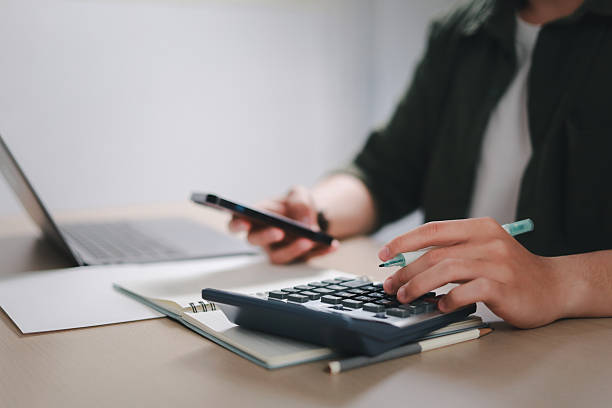 istock Businessman calculating budget, data analysis, documents, reports, tax refund calculation, tax calculation with calculator and laptop. 2206624908