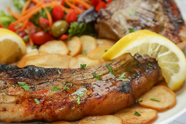 Pork chop with rib bone served with potato and green salad