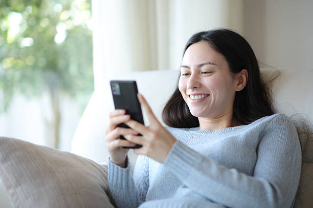 istock Happy asian woman is using smart phone at home 2206629574