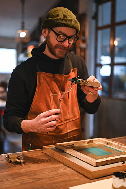 istock Focused craftsman preparing ink for silkscreen printing in his workshop, silk screen textile printery. 2206629740