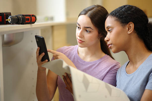 istock Interracial roommates checking phone renovating kitchen 2206629909