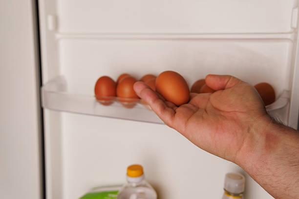 istock Hand removing an egg from fridge compartment symbolizing the surge in egg prices and food market inflation 2206630901