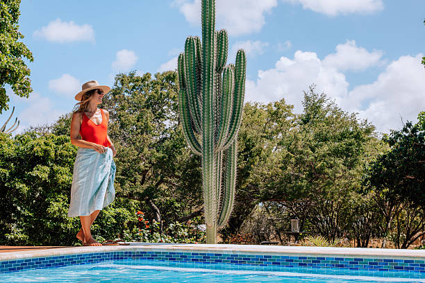istock Woman in Sun Hat by Poolside with Towel 2206631405