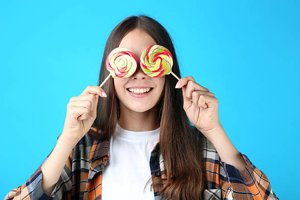 istock Young girl with lollipops on blue background 2206633199