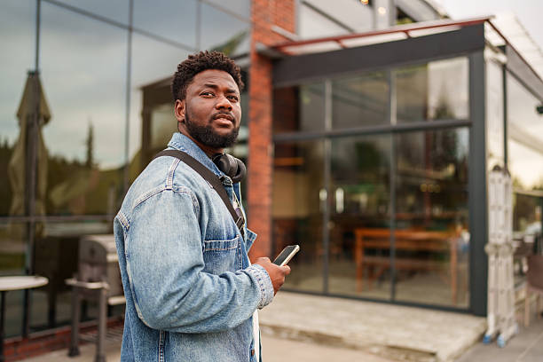 istock Young Black Man Using Smartphone with a Positive Expression on the Street 2206636463