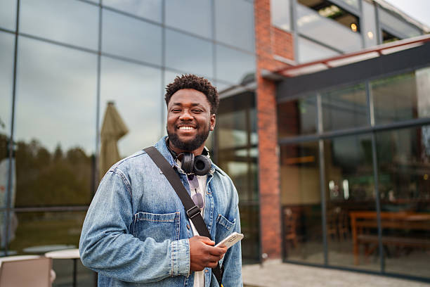 istock Young Black Man Using Smartphone with a Positive Expression on the Street 2206636539