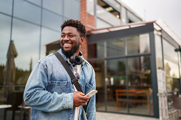 istock Young Black Man Using Smartphone with a Positive Expression on the Street 2206636553