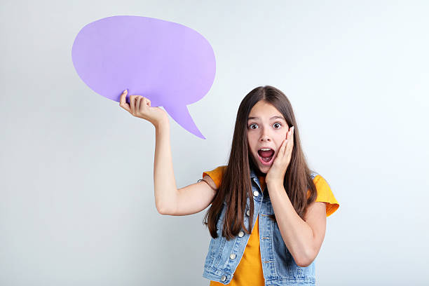 istock Young girl with speech bubble on grey background 2206636590