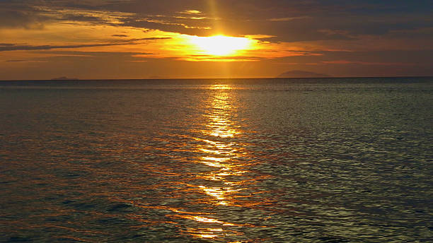 istock The sun sets behind the sea behind the clouds. 2206647480