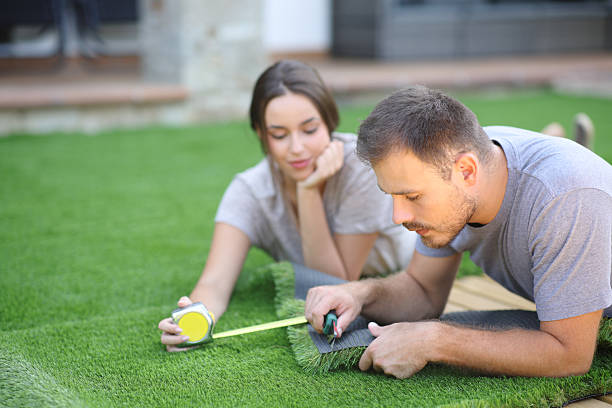 istock Couple at home installing artificial grass in the garden 2206648897