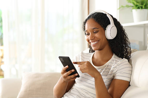istock Happy black woman using phone and headphone at home 2206648936