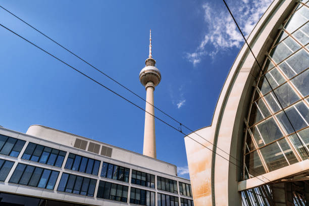 Dynamic composition showcasing the iconic Berlin Fernsehturm amidst contemporary architectural structures, set against a vibrant and clear blue sky.