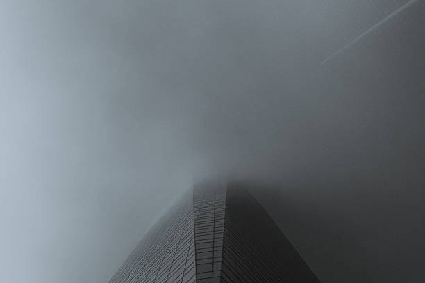 Low angle view of iconic urban architecture in downtown Chicago. Low clouds envelop the top of the skyscraper buildings.