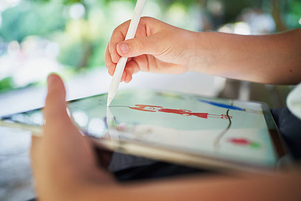 istock Elementary school student drawing on tablet with stylus pen outdoors 2206654687